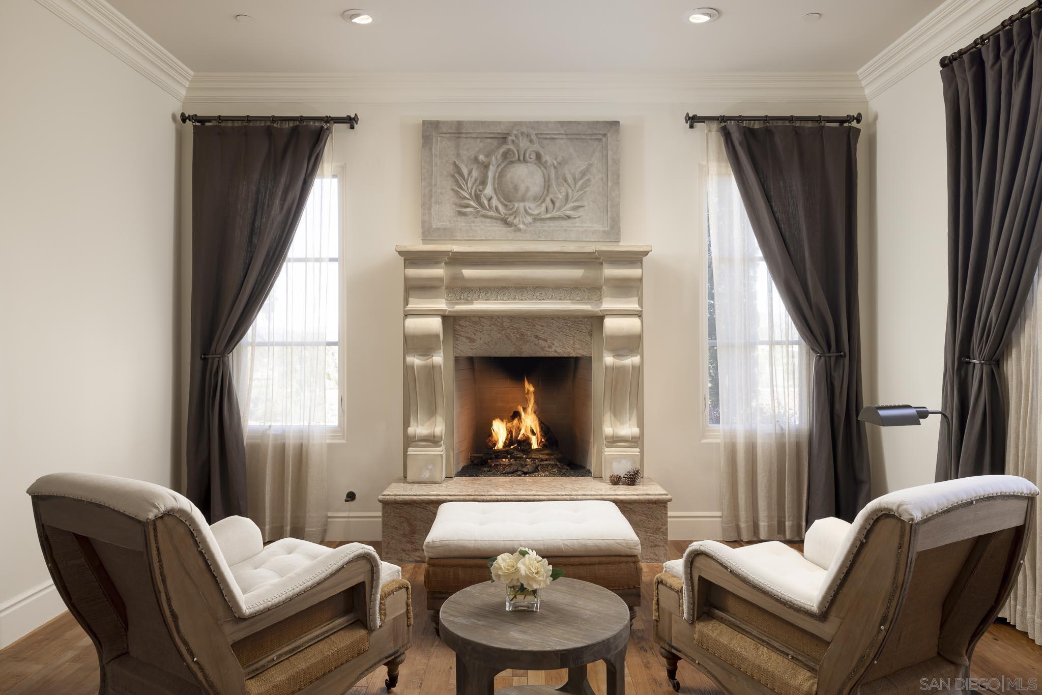 a living room with furniture a fireplace and a large mirror