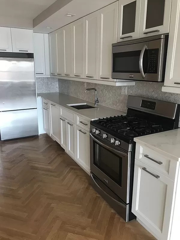 a kitchen with stainless steel appliances granite countertop a stove and a microwave