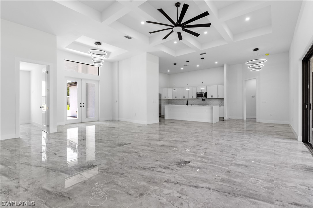 an empty room with kitchen and windows