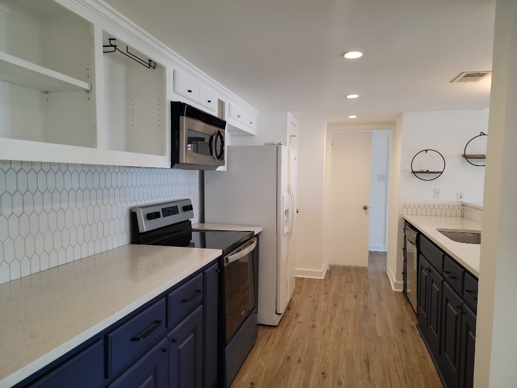 a kitchen with a sink and wooden floor