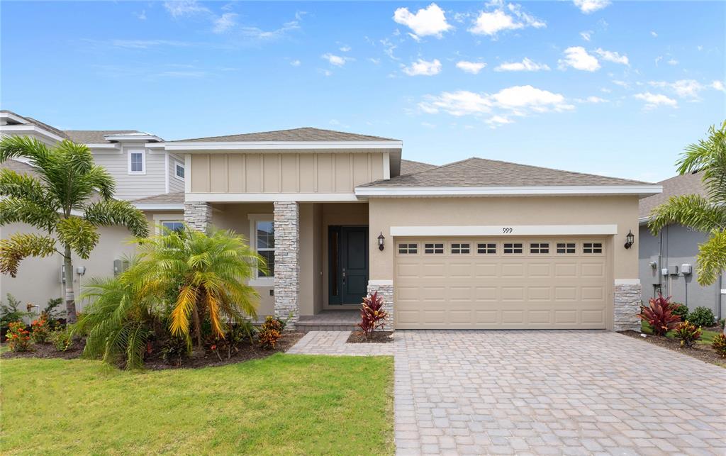 a front view of a house with a garden and garage