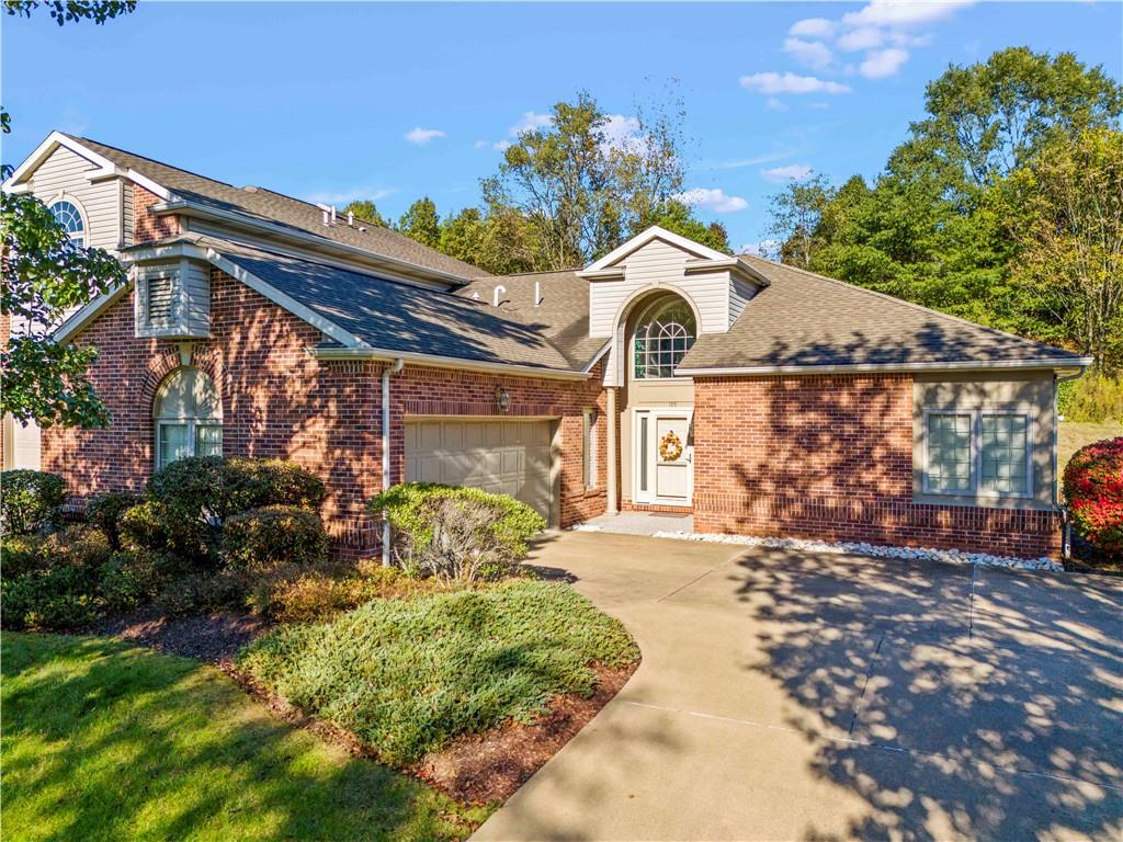 a front view of a house with a big yard and a large tree