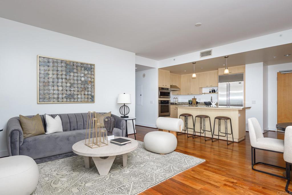 a living room with furniture and a dining table with wooden floor