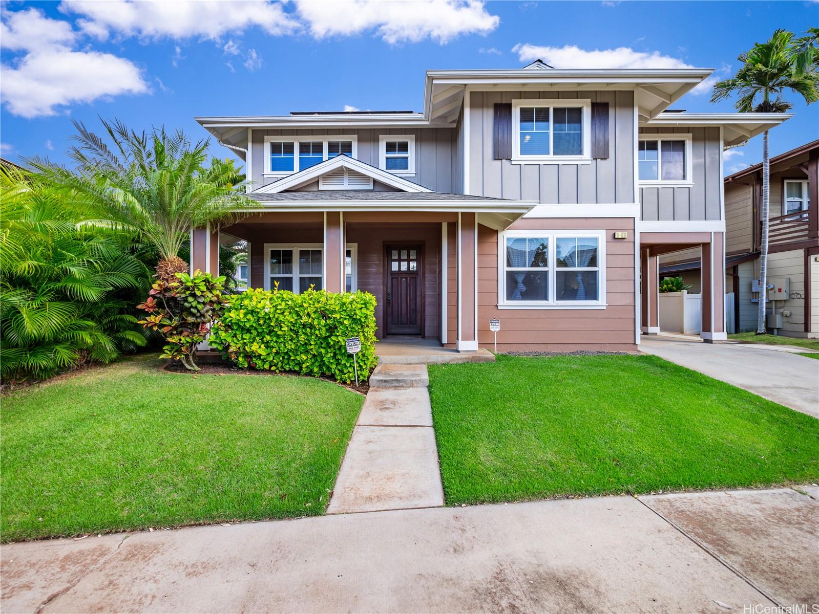 a front view of a house with a yard and potted plants