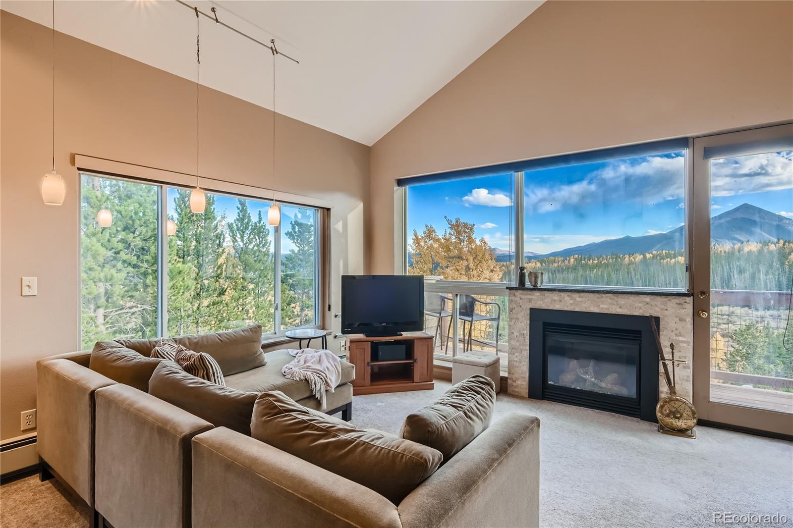 a living room with furniture a large window and a fireplace