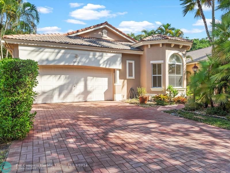 a front view of a house with a yard and a garage