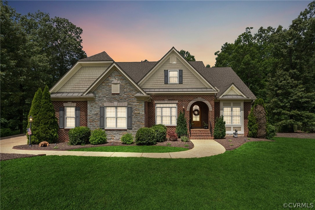 a front view of a house with a yard and green space