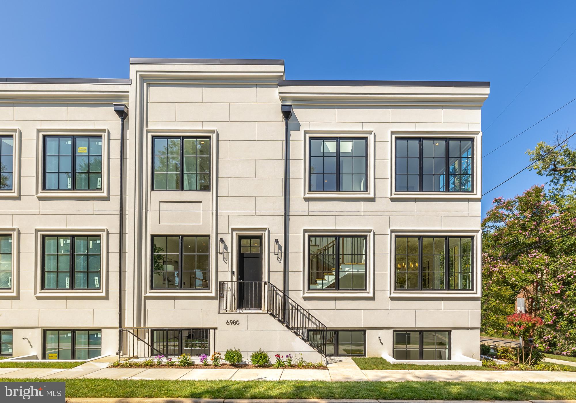 a front view of a residential apartment building with a yard