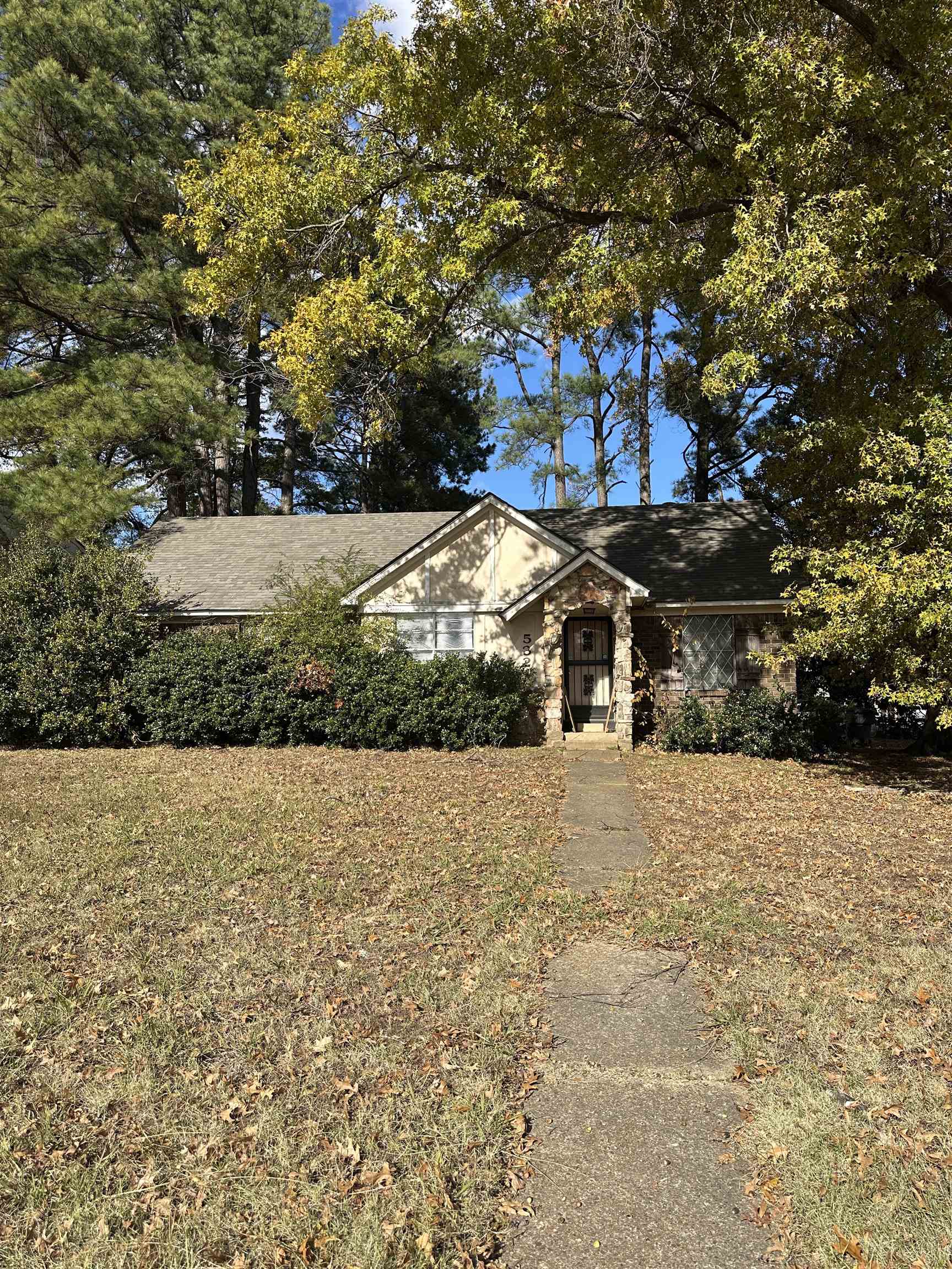 a backyard of a house with a yard and large trees