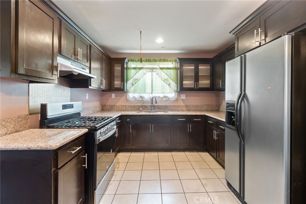 a kitchen with a sink a stove cabinets and a refrigerator