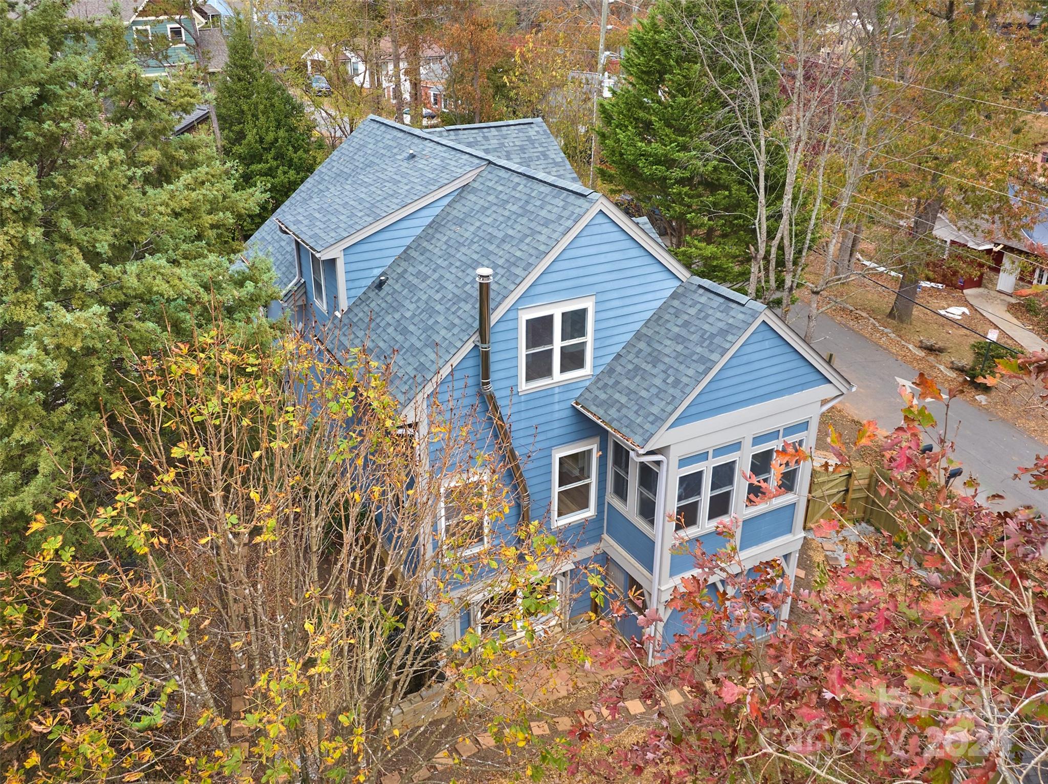 a aerial view of a house with yard and trees