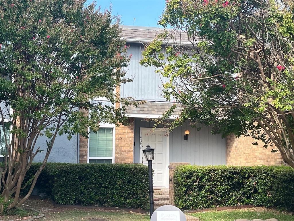 front view of a house with a tree