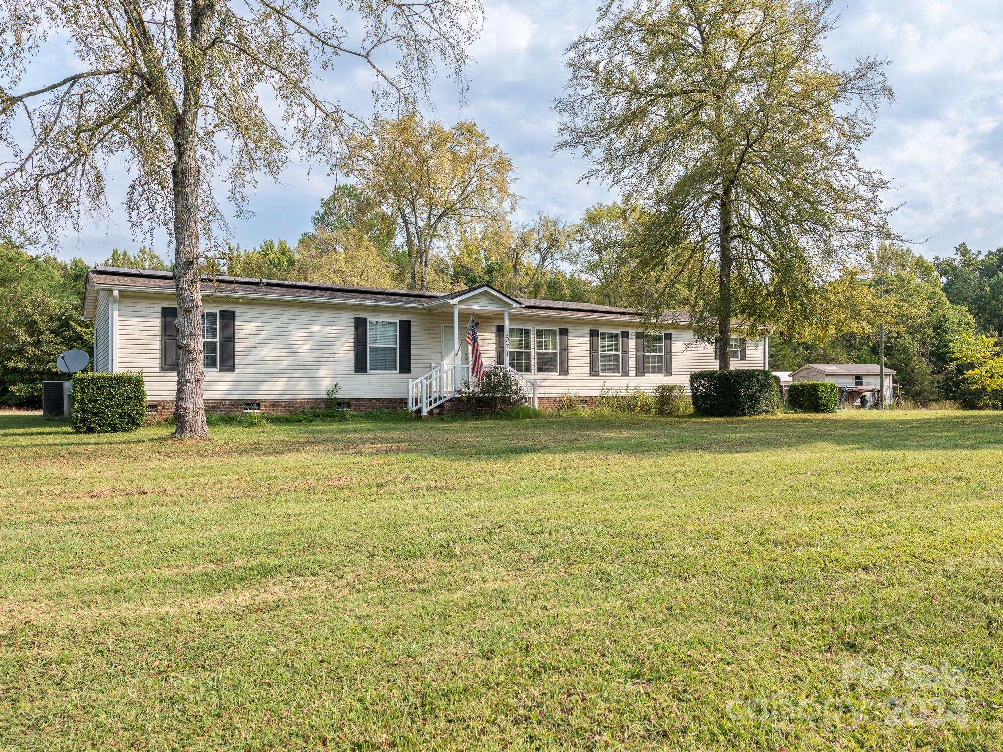 a front view of house with yard and trees