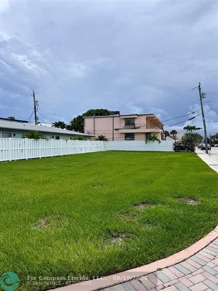 a view of a house with a big yard and large trees