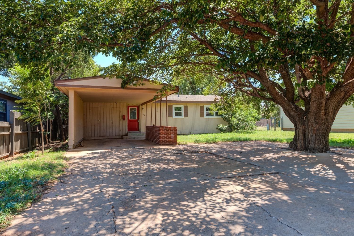 a view of a house with a tree in front of it