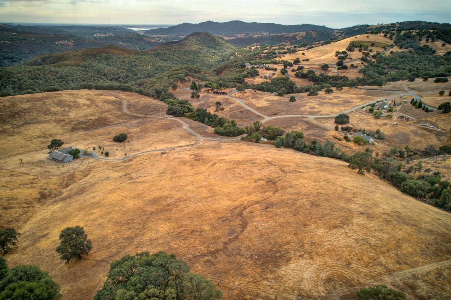 a view of a dry yard with mountains in the background