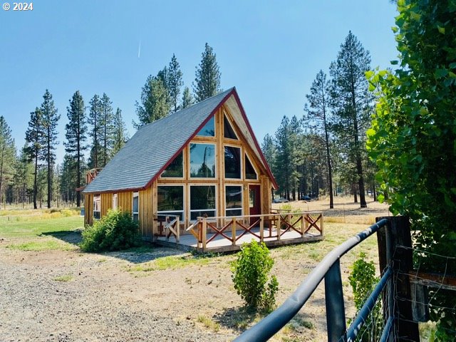 a view of a house with backyard and trees