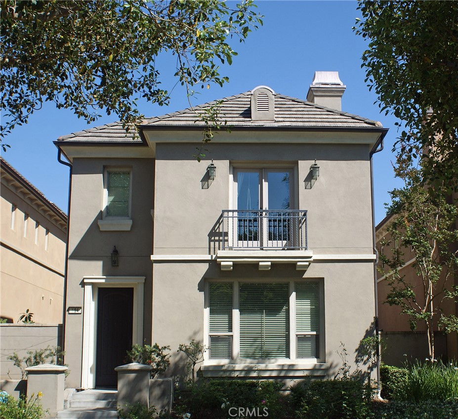 a view of a white house with large windows and a small yard