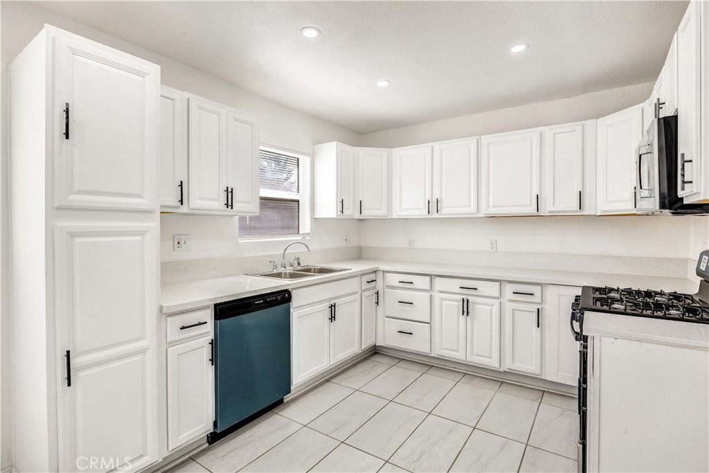 a kitchen with stainless steel appliances granite countertop white cabinets sink and dishwasher