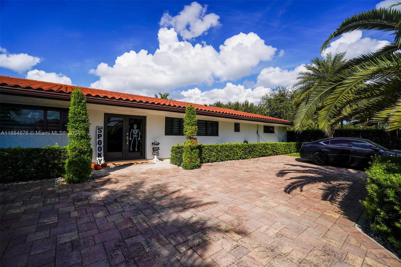 a front view of house with yard and trees around