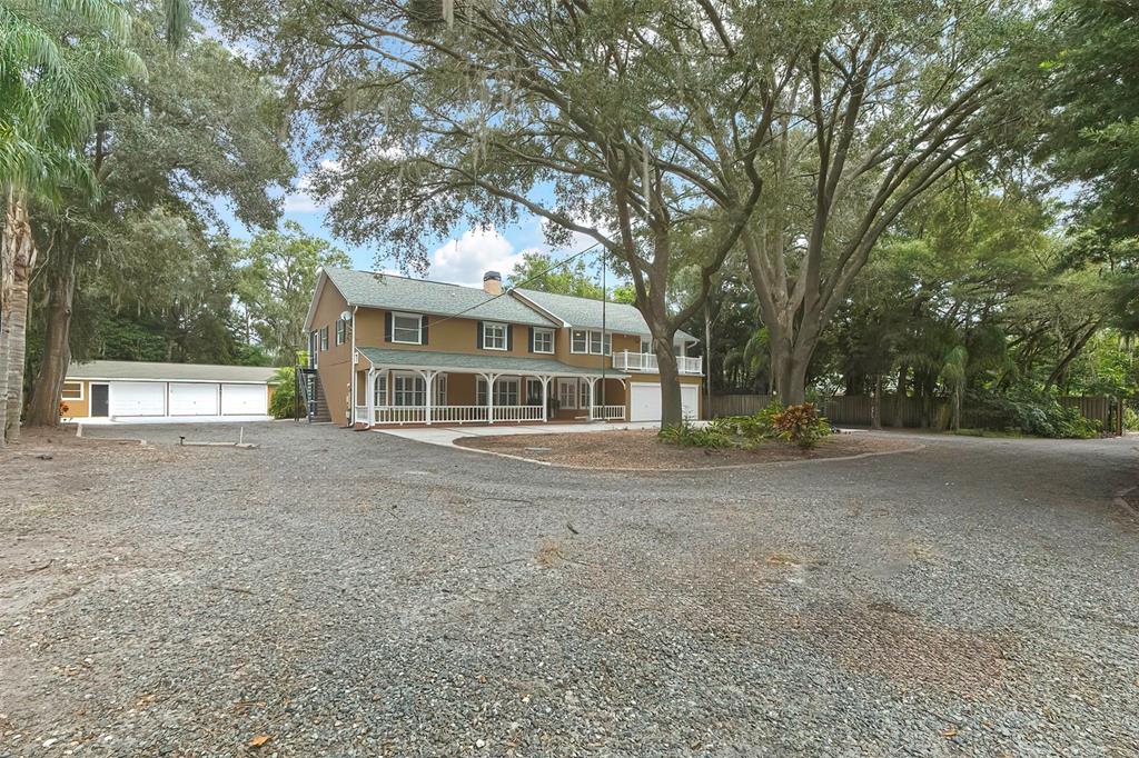 a view of a house with a large tree and many windows