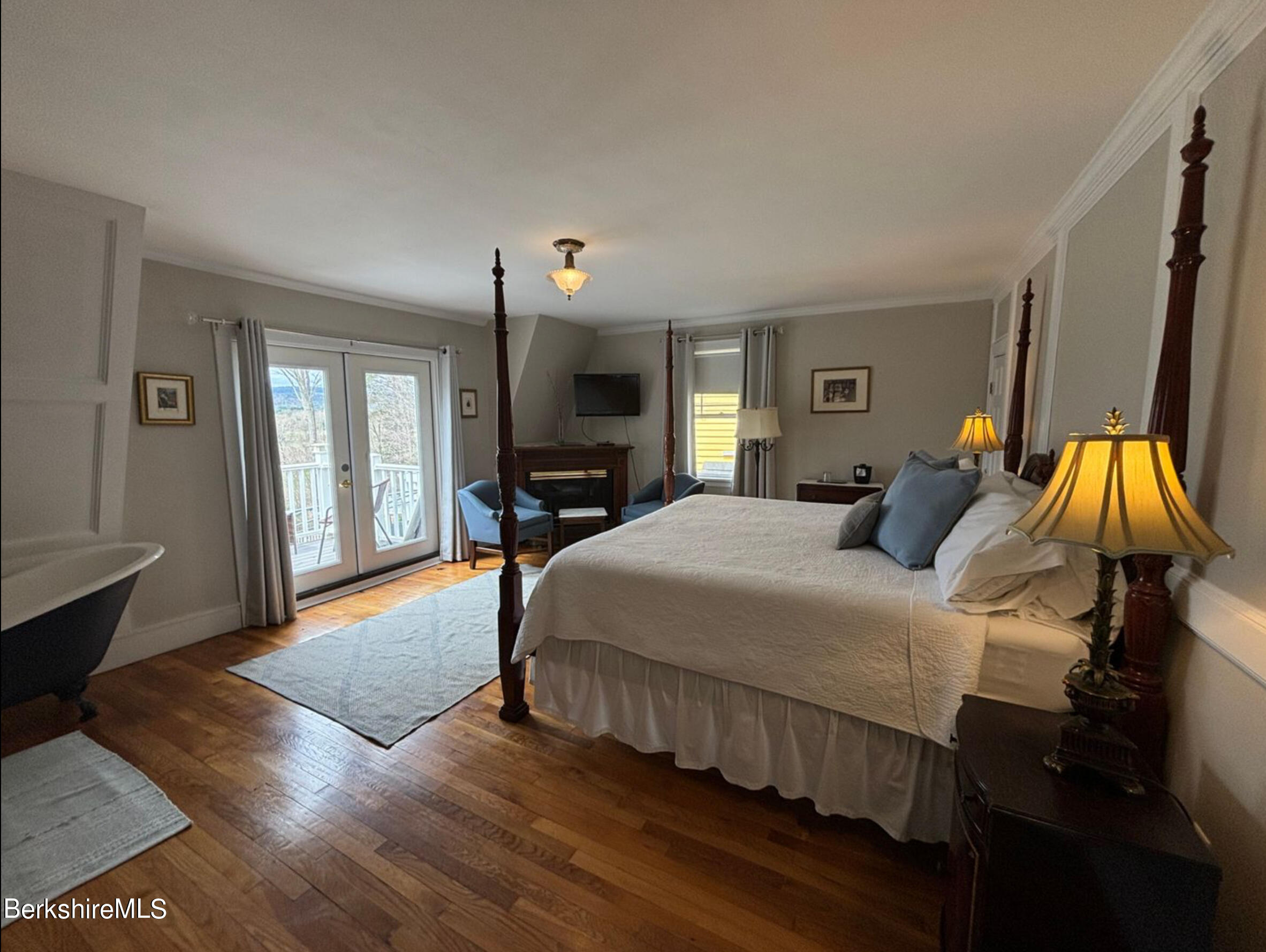 a spacious bedroom with a bed and wooden floor