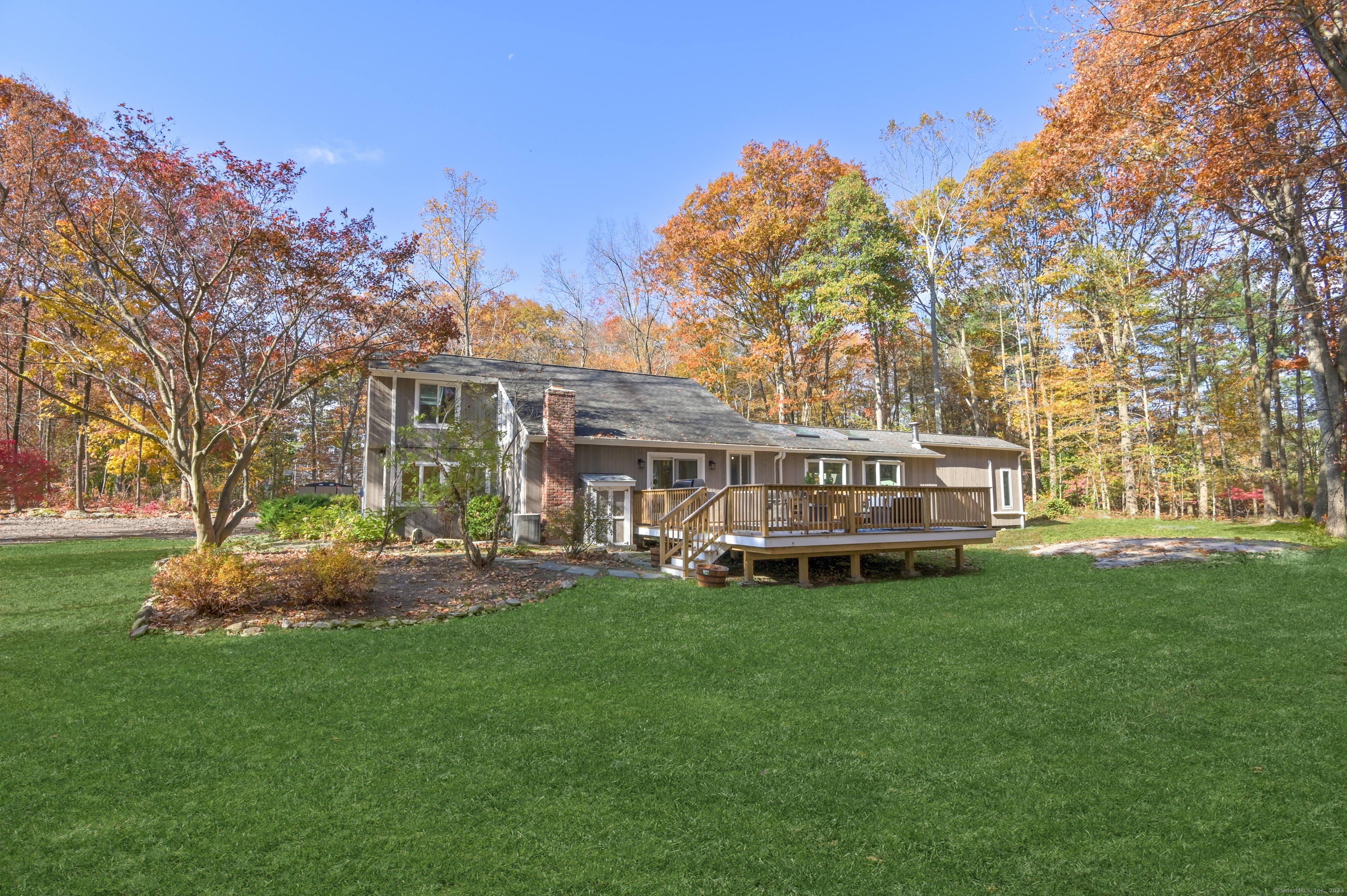 a view of a house with a big yard and large trees