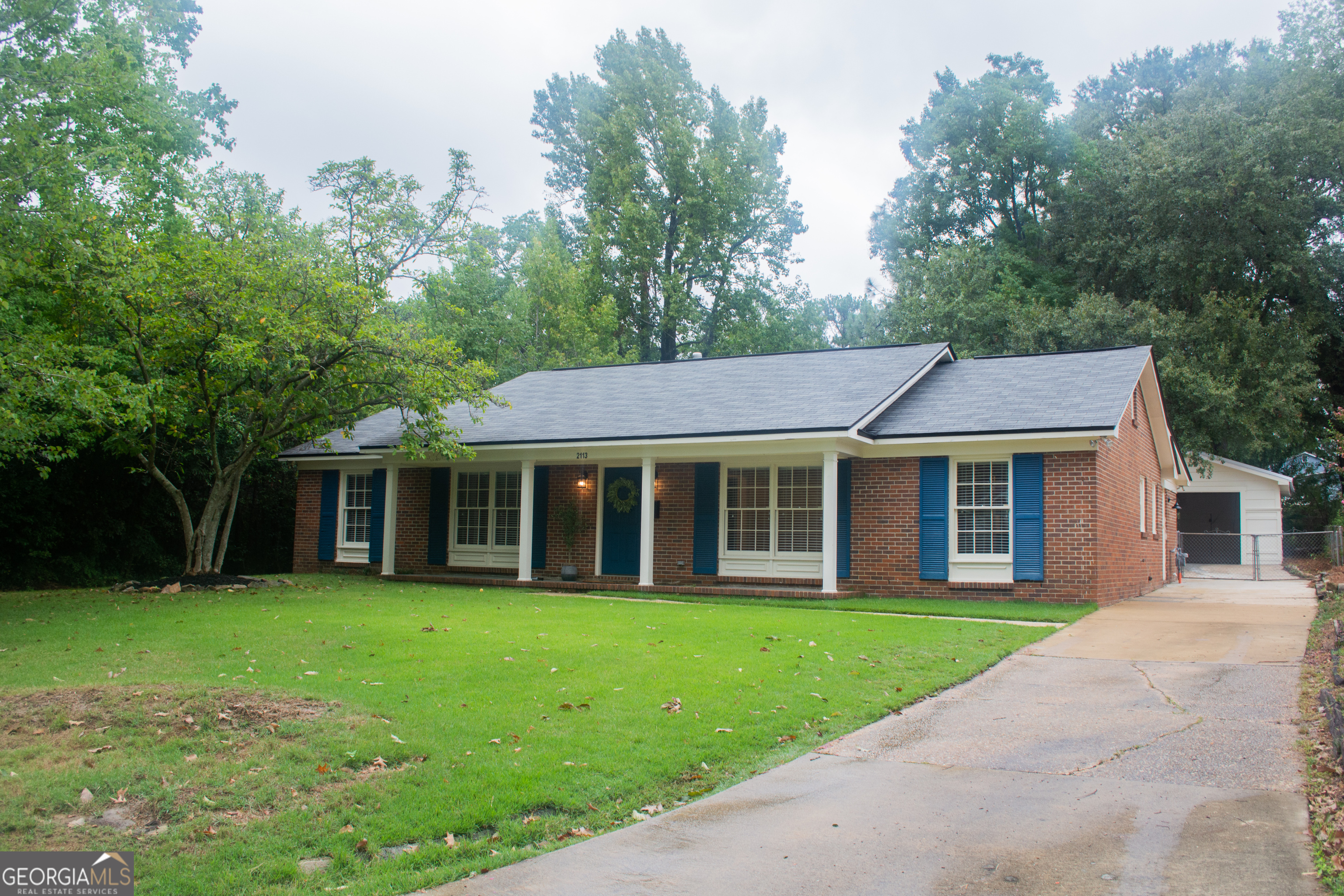 a view of a house with a yard and sitting area