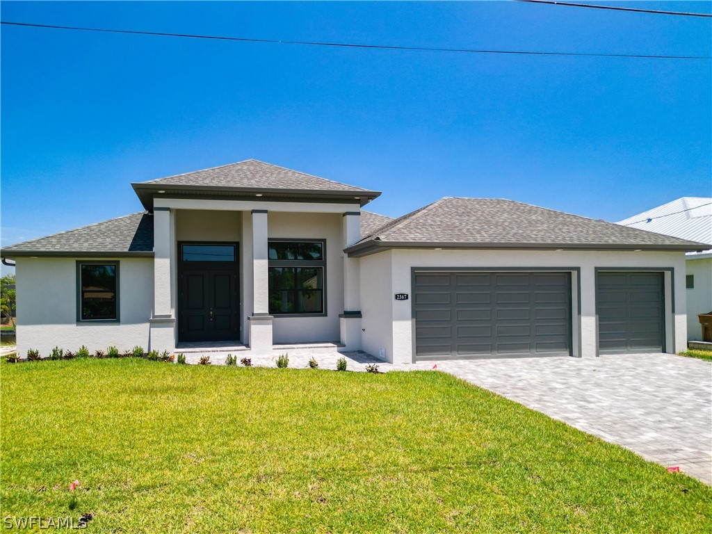 a front view of a house with yard and garage