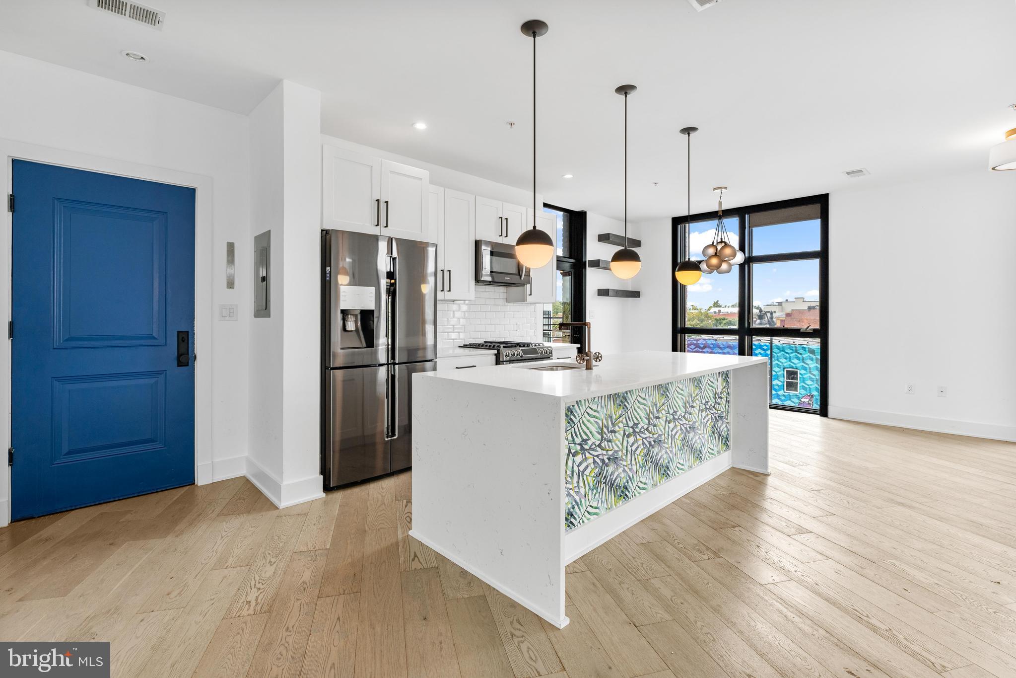 a kitchen with stainless steel appliances granite countertop a refrigerator and a stove