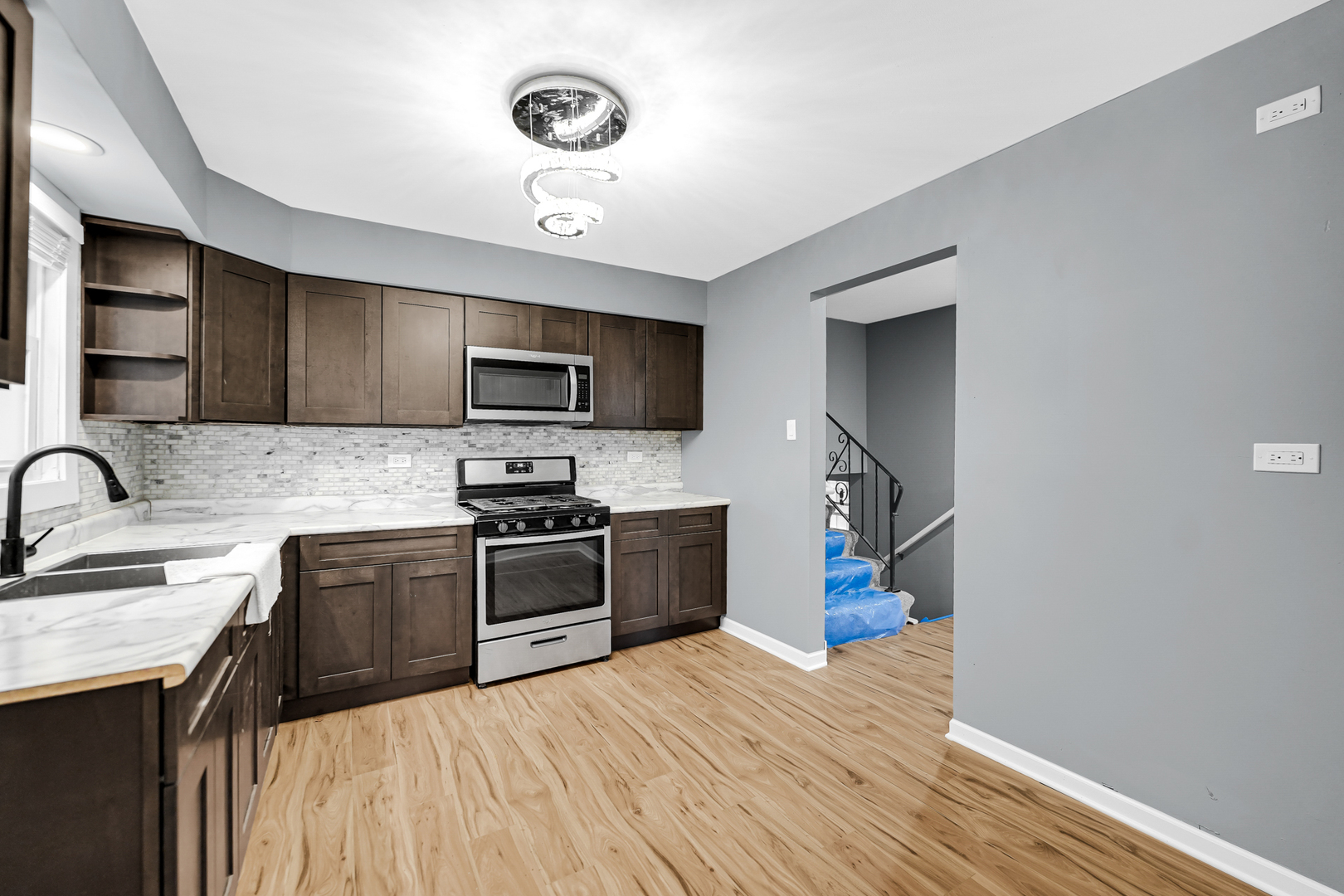 a kitchen with a sink stainless steel appliances cabinets and a counter top space