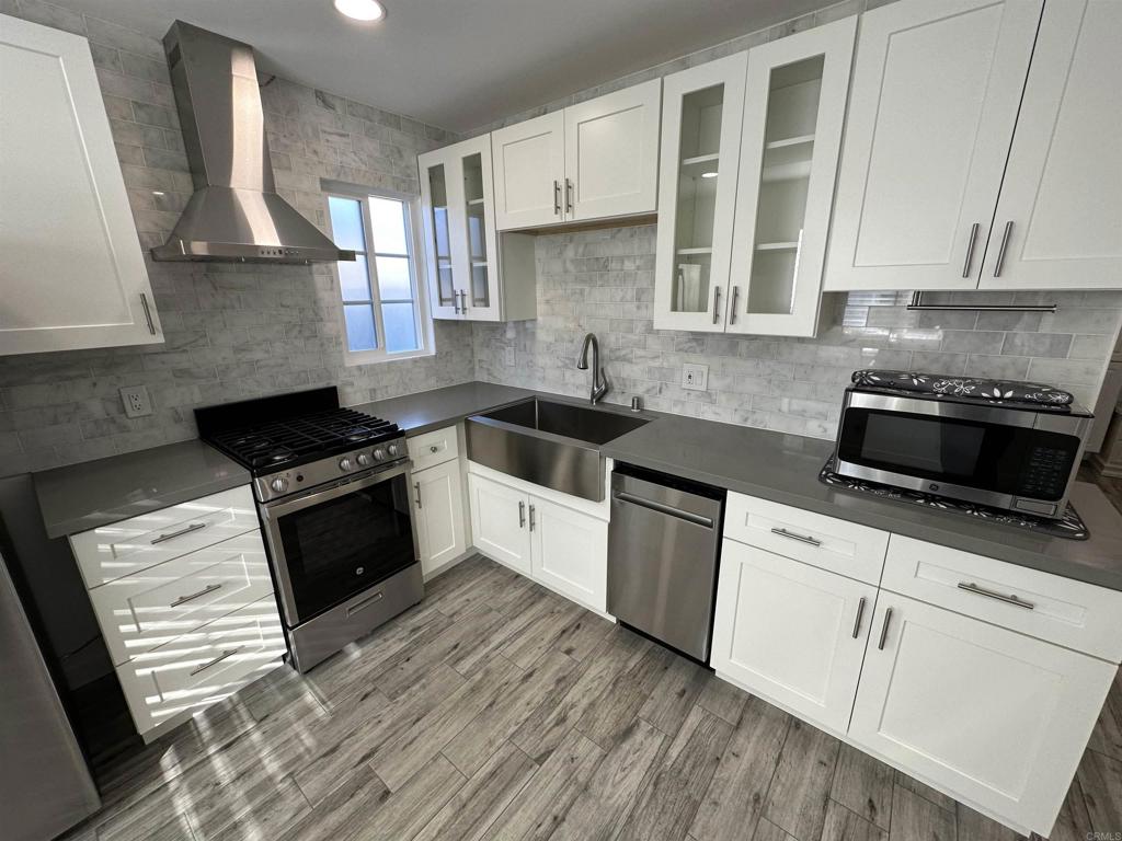 a kitchen with granite countertop a sink a stove and cabinets