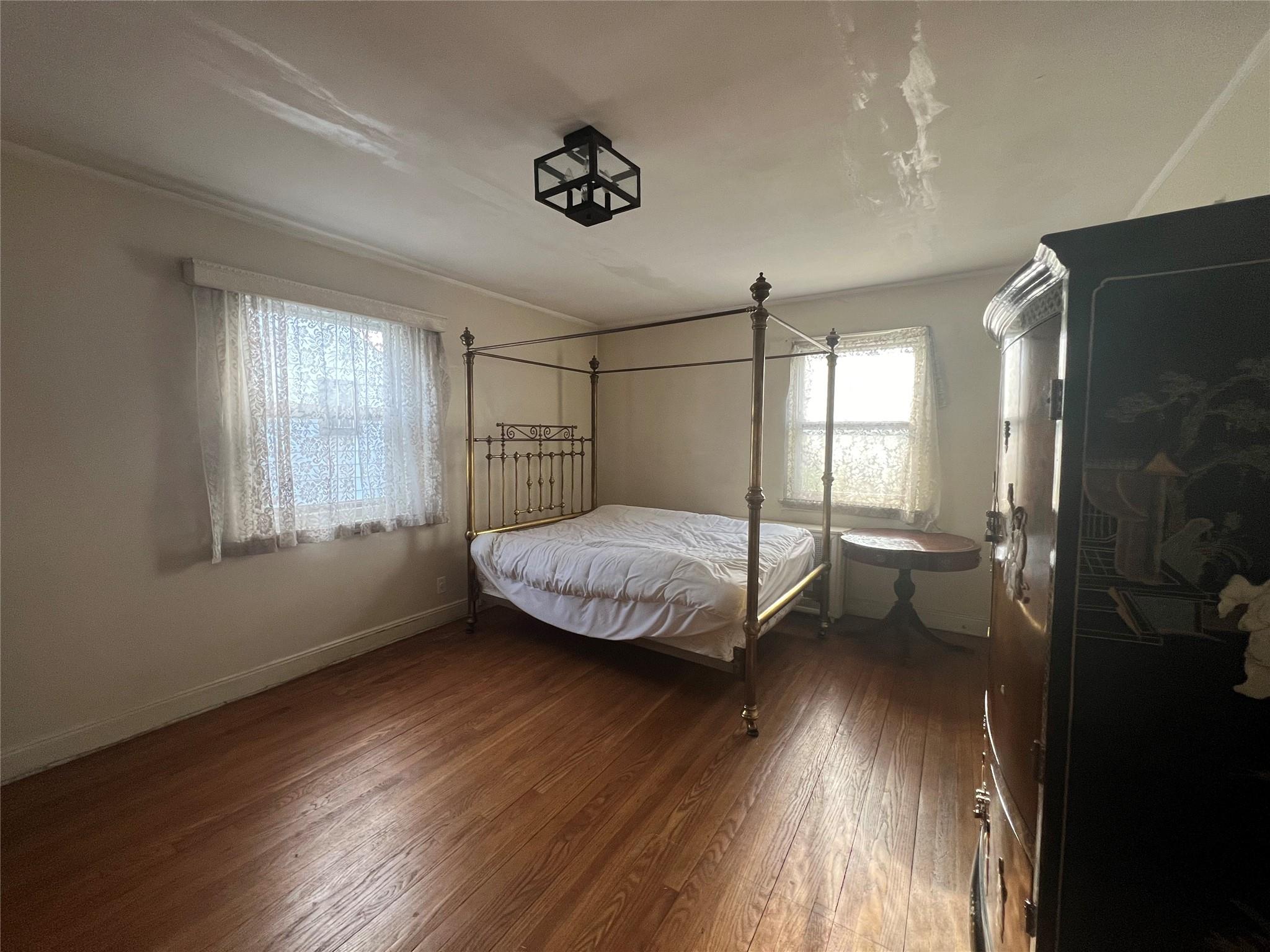 Bedroom with dark hardwood / wood-style flooring