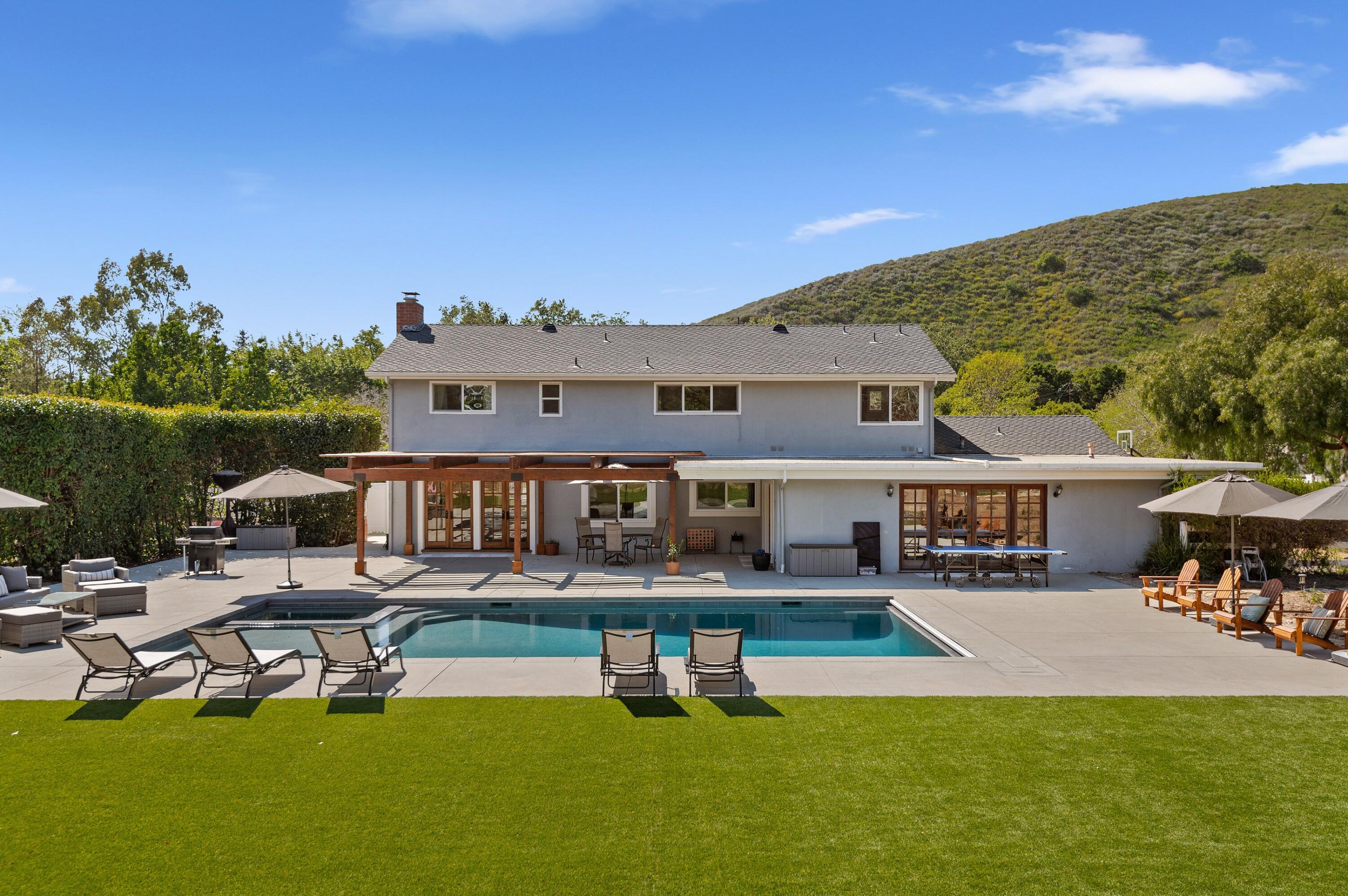 a view of a house with swimming pool and sitting area