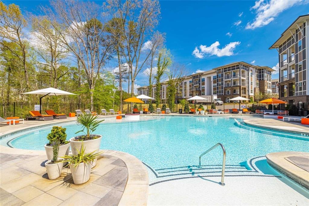 a view of a swimming pool with a lawn chairs under an umbrella