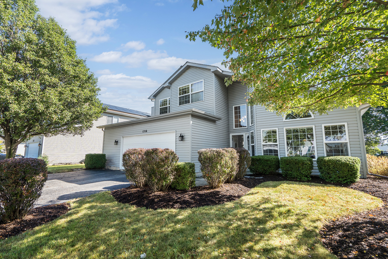 a front view of a house with a yard and outdoor seating