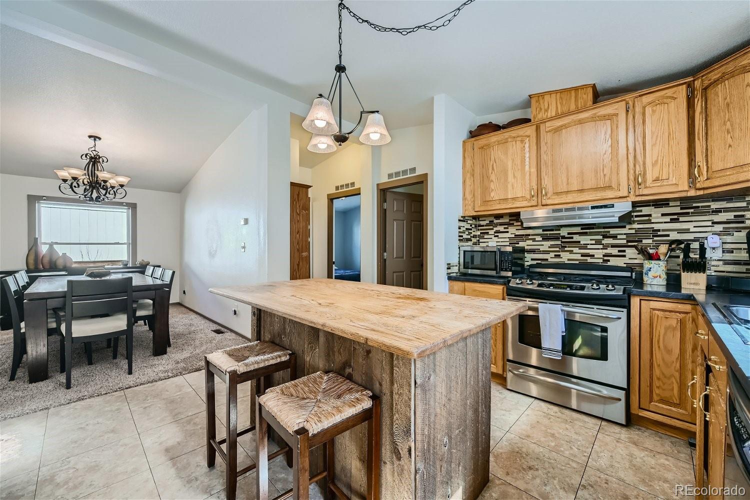 a kitchen that has a stove a table and chairs in it