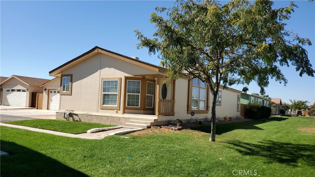 a front view of a house with a yard and trees