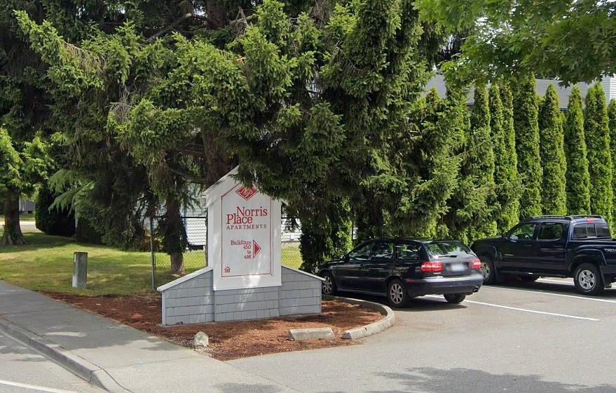 a front view of a house with a garden and parking space