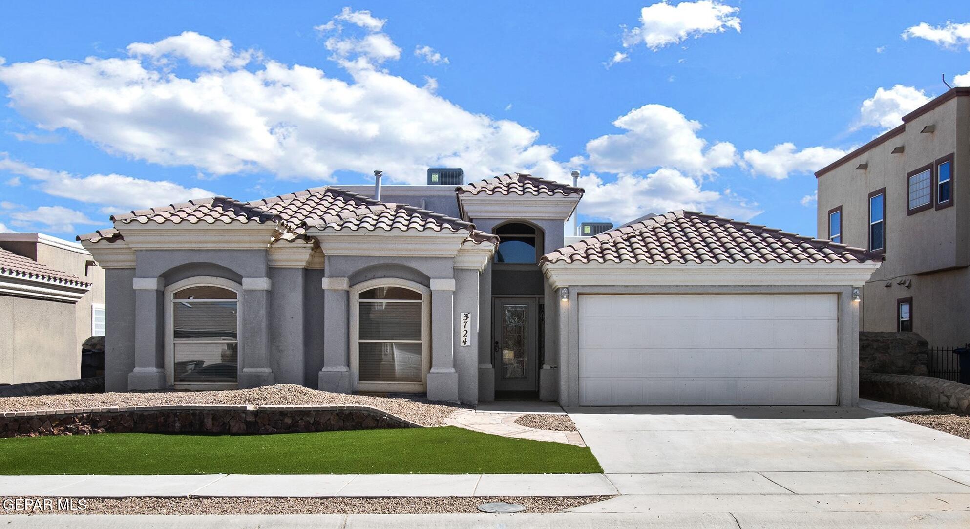 a front view of a house with a yard and a garage