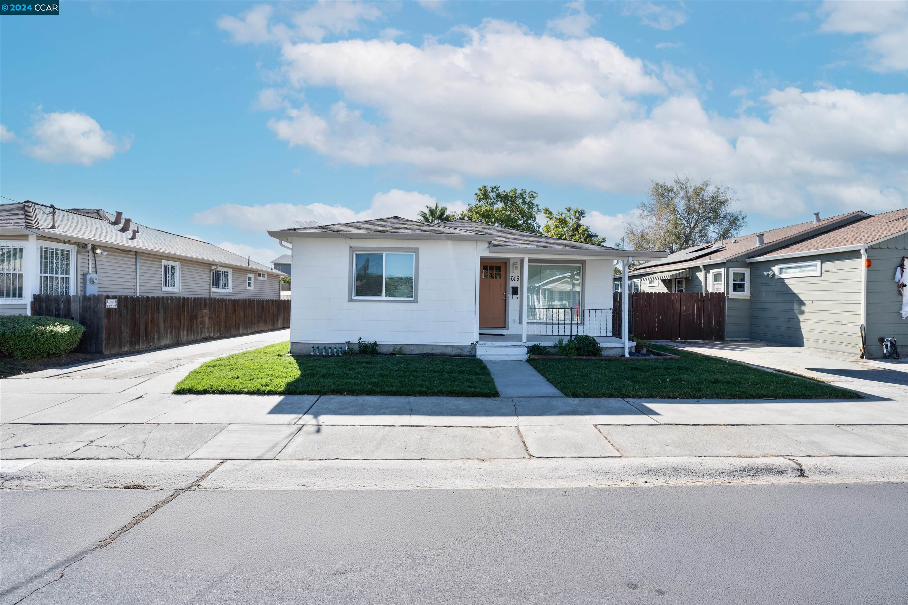 a view of a house with a yard and large parking space