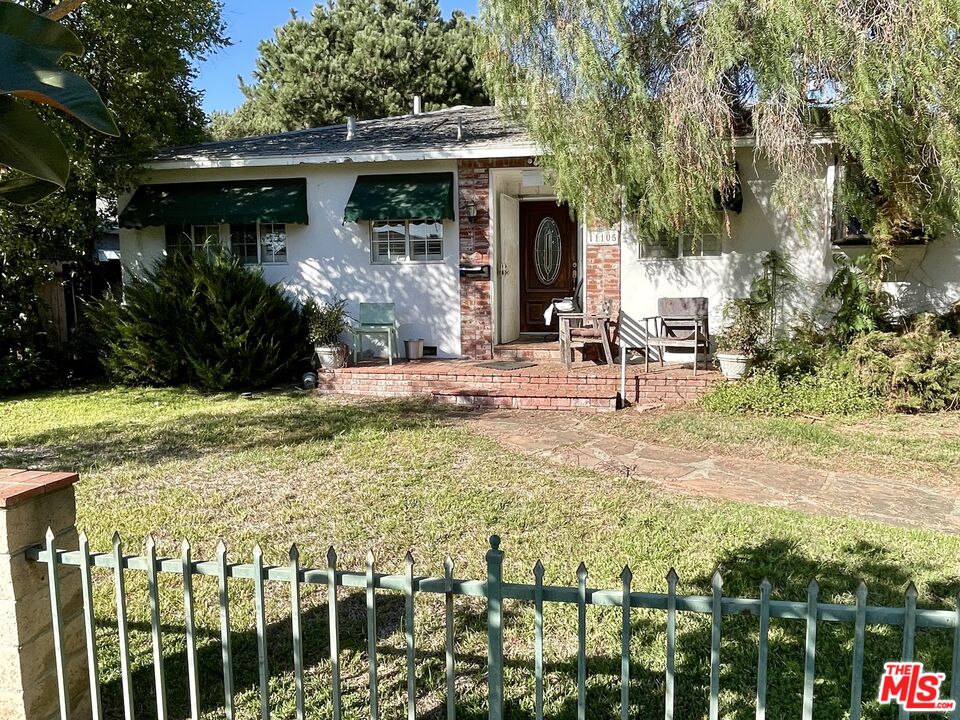 a view of a house with backyard and sitting area