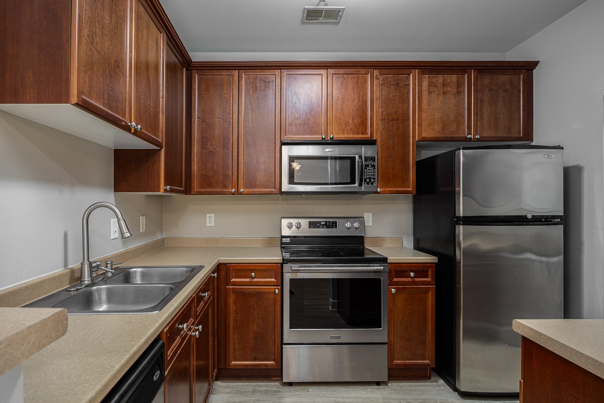 a kitchen with stainless steel appliances granite countertop a refrigerator sink and stove