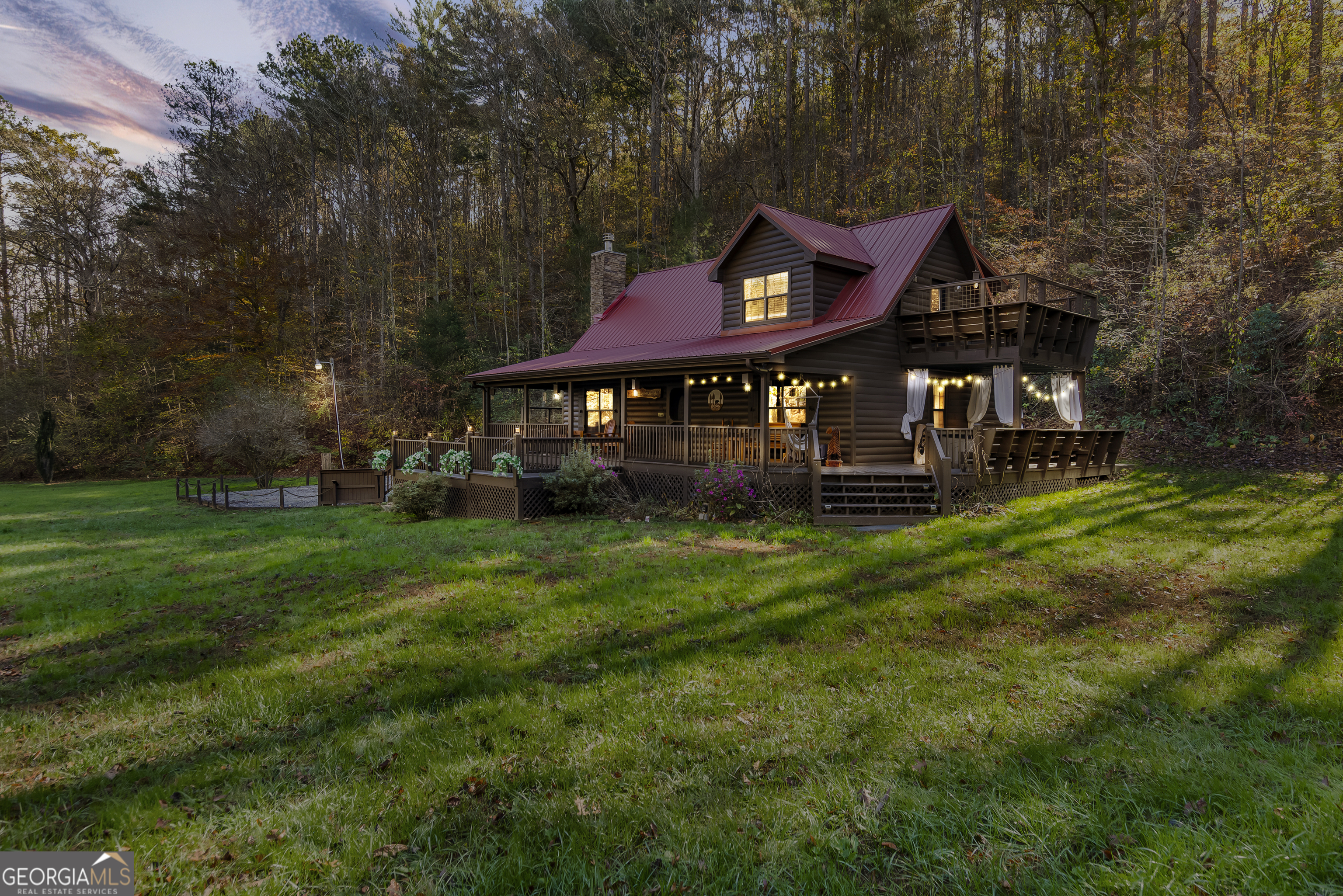 a view of a house with a big yard and large trees