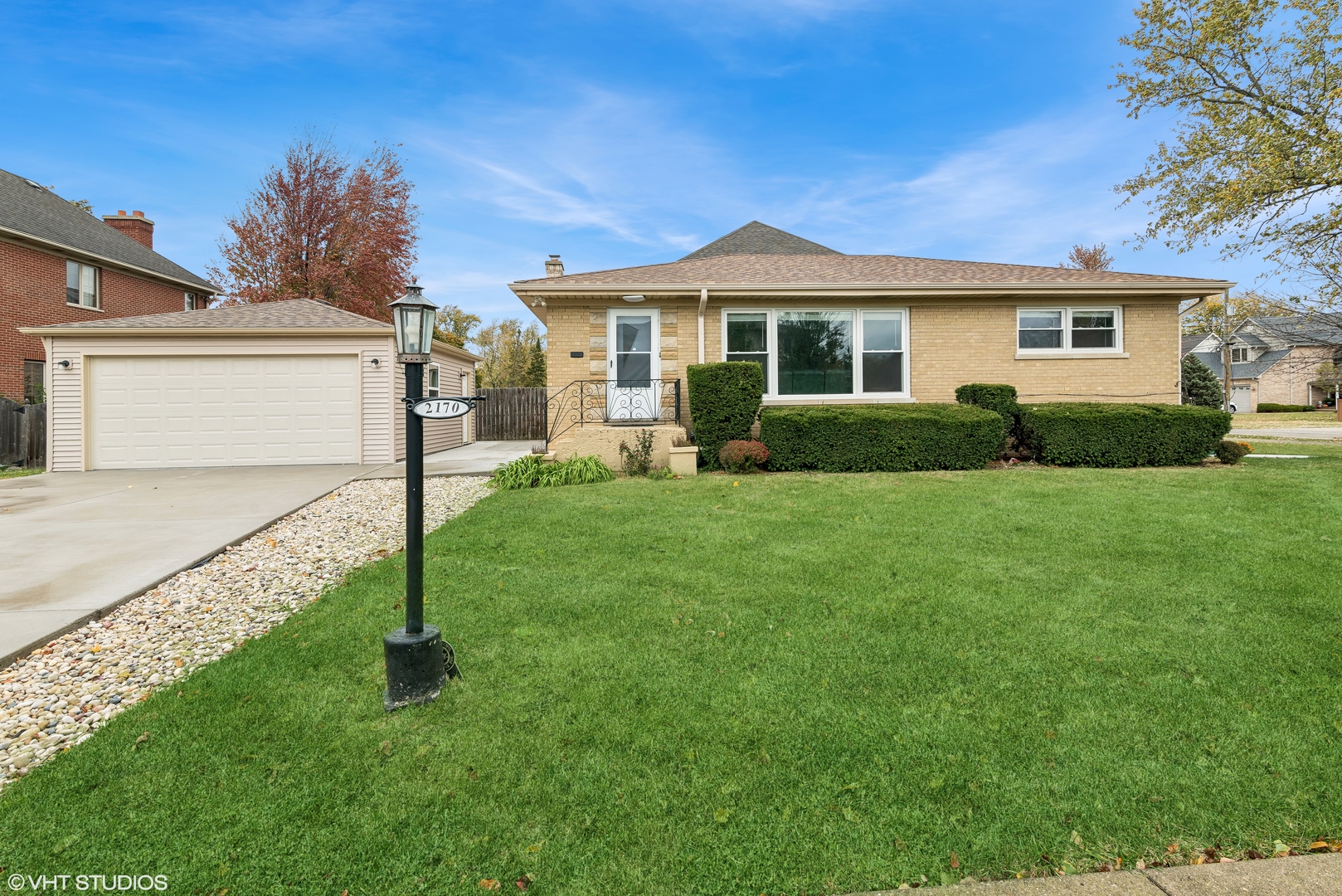 a front view of a house with a garden and yard