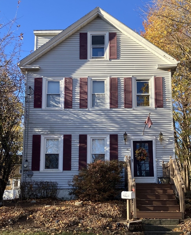 a front view of a house with yard and parking