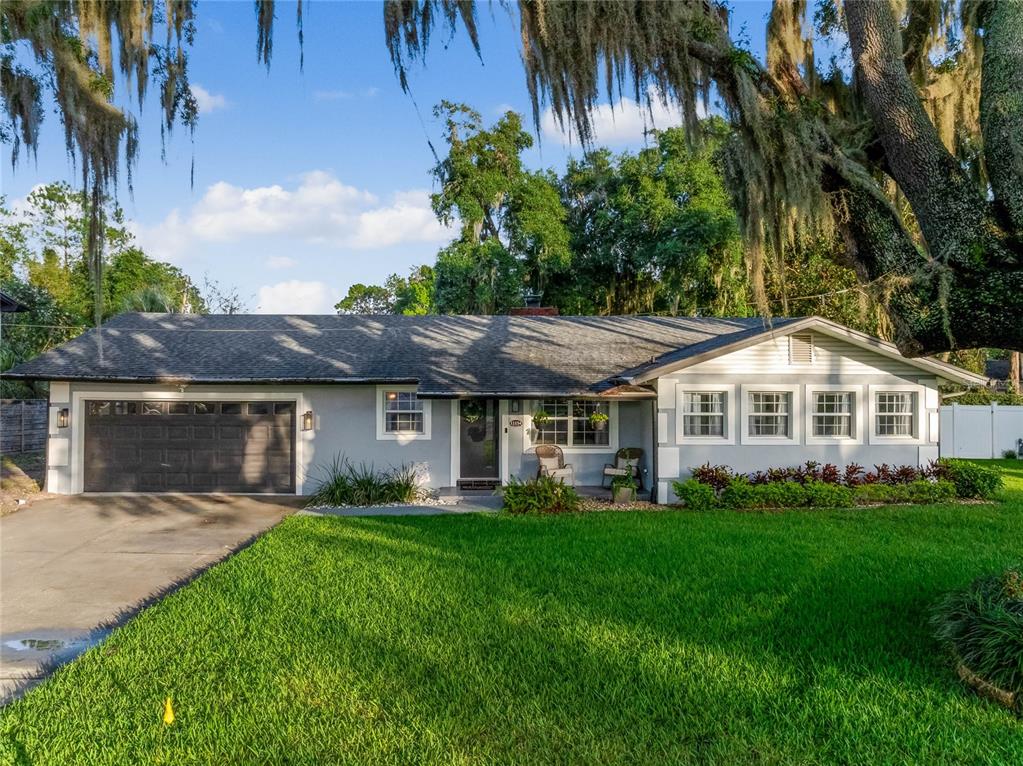 a front view of a house with a yard and trees