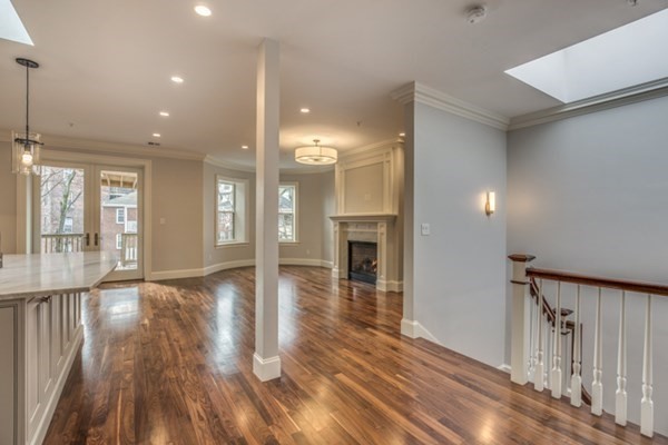 a view of a hallway with wooden floor and a fireplace