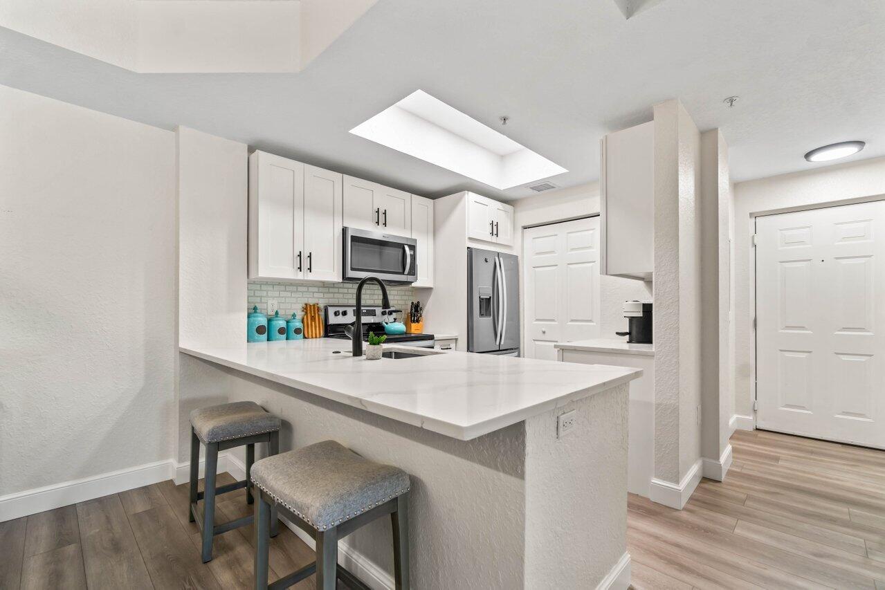 a kitchen with stainless steel appliances a sink and a refrigerator