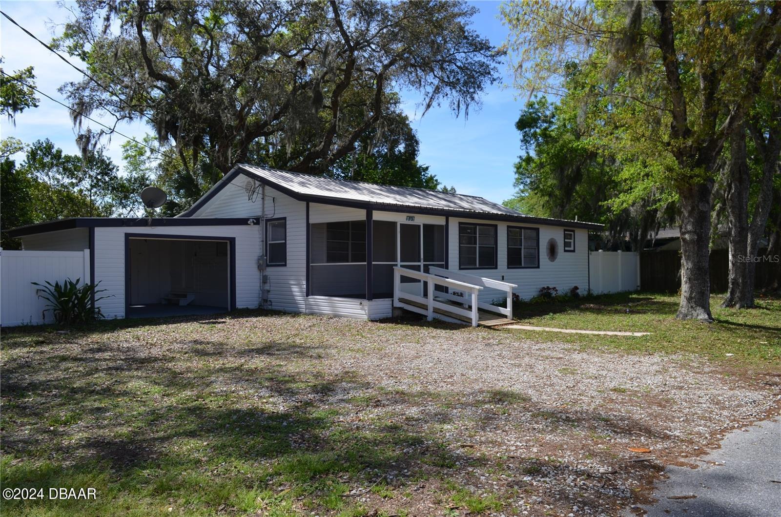 a view of a house with backyard and trees